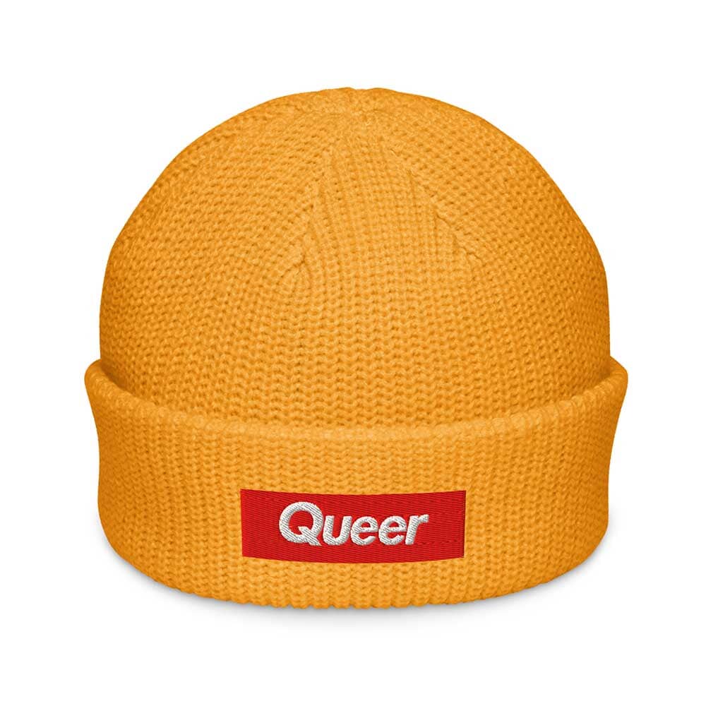 Gold beanie with a red 'Queer' patch on a white background