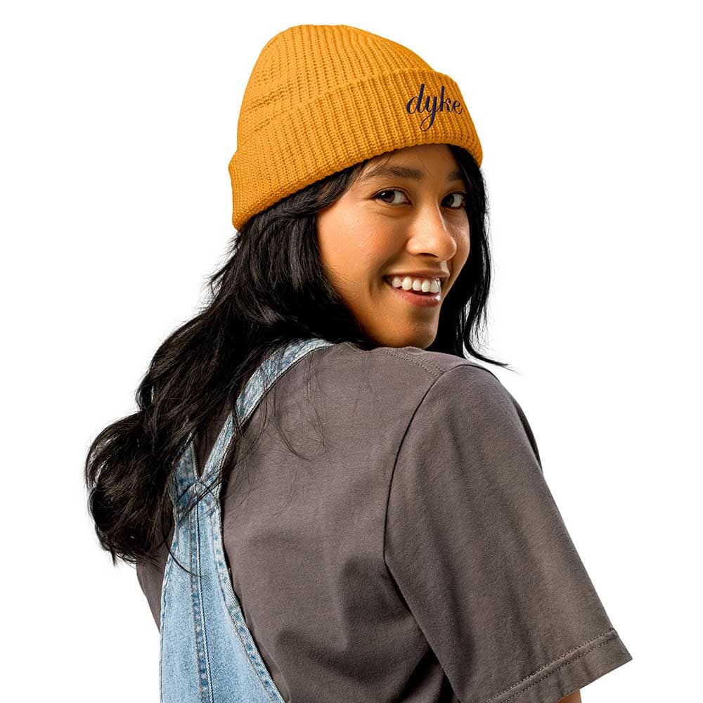 Person wearing a mustard yellow beanie with &