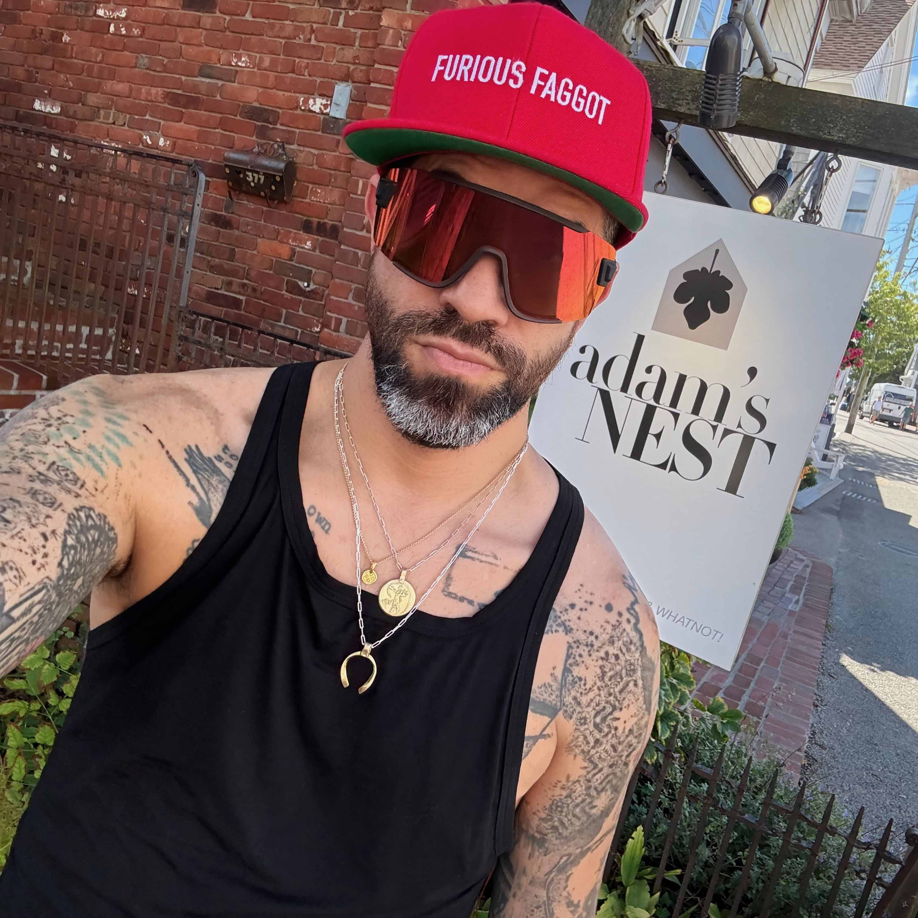 ryan wearing furious faggot red flatbill outside adam's nest