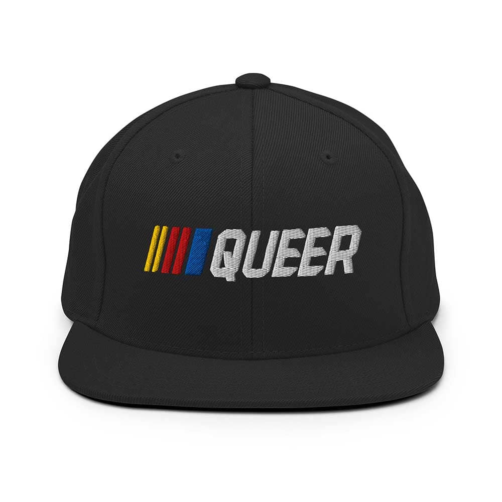 Black snapback flatbill cap with 'QUEER' in colorful letters on a white background