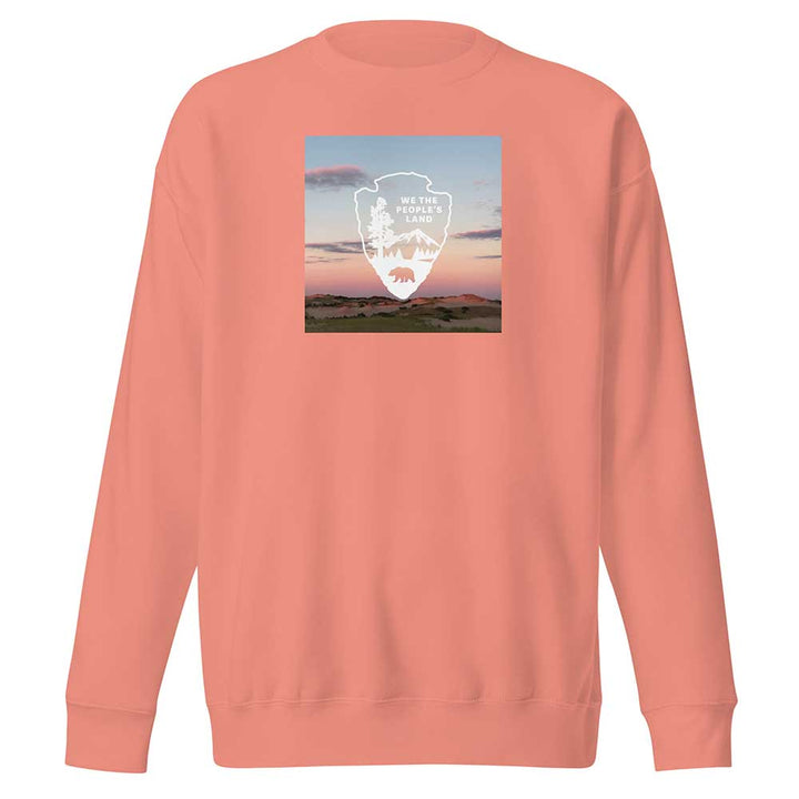 Peach-colored sweatshirt with a graphic design on the chest against a white background