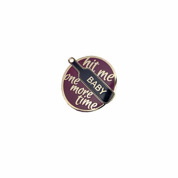 enamel pin with paddle and the phrase hit me baby one more time