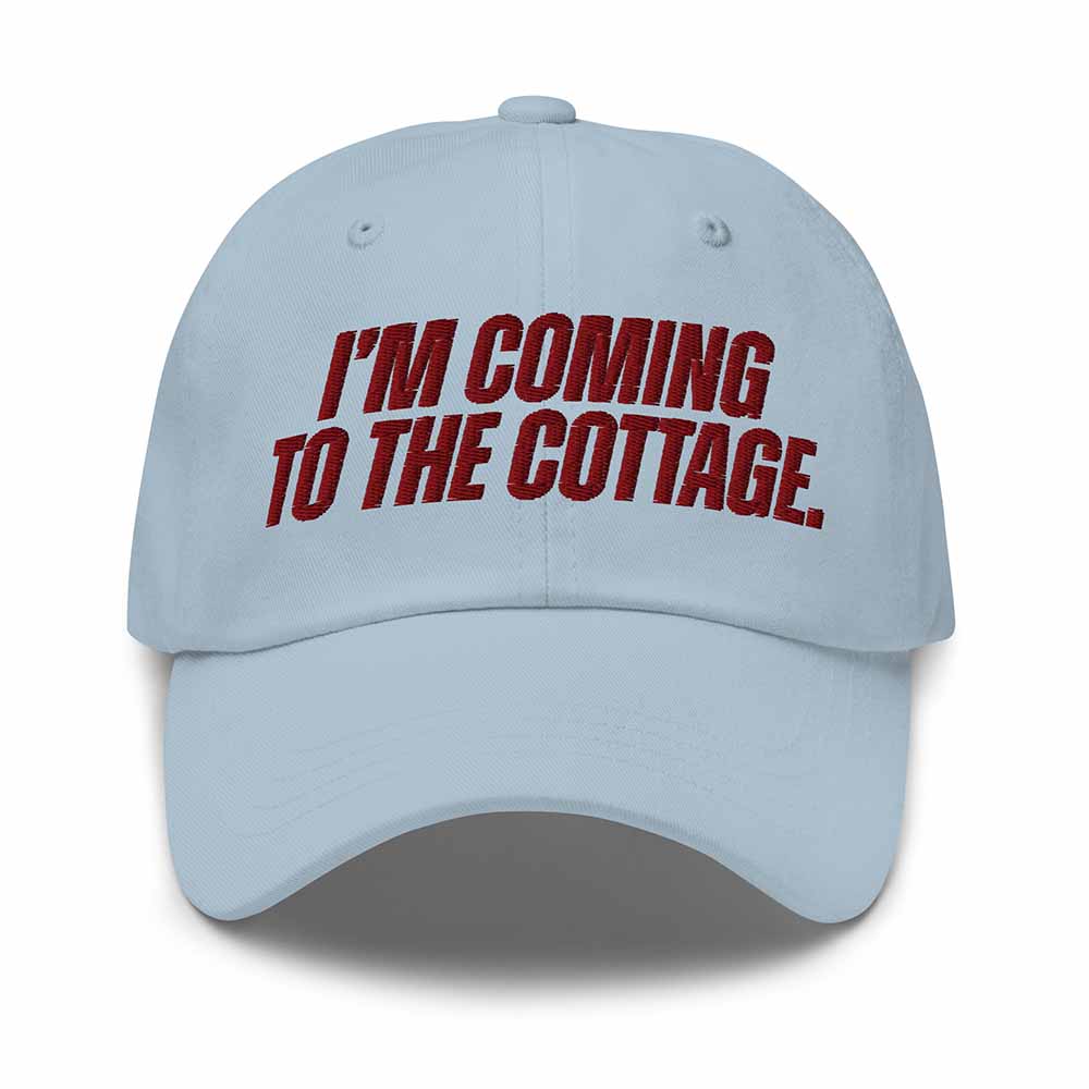 Light blue cap with red text 'I'm Coming to the Cottage' on a white background