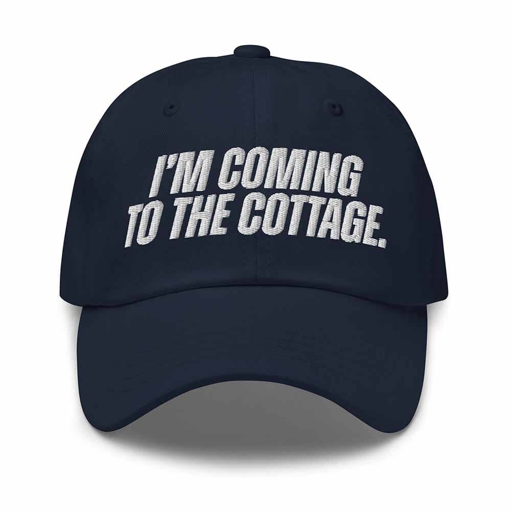 Navy blue cap with white text 'I'm Coming to the Cottage' on a white background